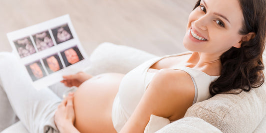 Pregnant woman looking at ultrasound photos